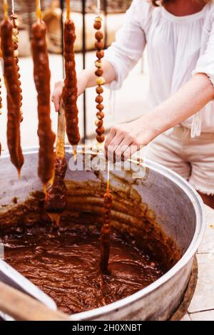 Hausgemachtes Rezept und Prozess der Herstellung von churchkhela - georgische Süßigkeiten aus Haselnüssen und Traubensaft Stockfoto