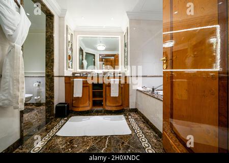 Interieur mit luxuriösem Badezimmer in Marmor, mit zwei Waschbecken, großem Spiegel und Accessoires, Luxusunterkunft im Ritz Carlton Moscow Hote, Russland Stockfoto