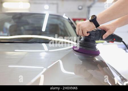 Master poliert Karosserie mit Poliermaschine Stockfoto