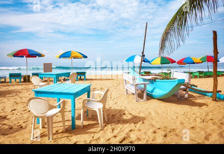 Tische und Stühle an einem tropischen Strand, Sommerurlaubskonzept, Sri Lanka. Stockfoto