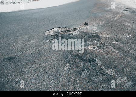 Grube und Schlagloch im Asphalt auf der Straße - schlechte Qualität Pflaster Stockfoto