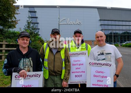 Street, Somerset, Großbritannien. Oktober 2021. Abgebildet sind Streikende mit jahrzehntelanger Dienstbebauung, die entlassen werden, wenn sie den neuen Vertrag nicht akzeptieren. Mitarbeiter des Vertriebszentrums der Clarks Shoe Fabrik in Somerset protestieren gegen die Praktiken, die sie als „Feuer und Wiederanstellung“ bezeichnen. Seit dem 4. Oktober streiken sie. Die Arbeitnehmer werden von der Gewerkschaft der Gemeinschaft unterstützt. Clarks gehört der in Hongkong ansässigen Venture Capital-Gesellschaft Lionrock. Kredit: JMF Nachrichten Stockfoto