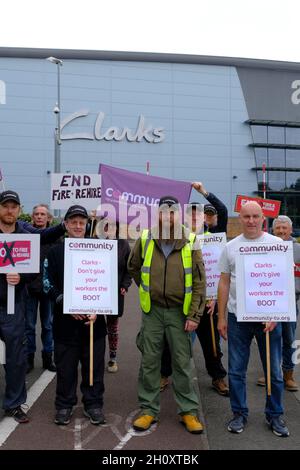 Street, Somerset, Großbritannien. Oktober 2021. Mitarbeiter des Vertriebszentrums der Clarks Shoe Fabrik in Somerset protestieren gegen die Praktiken, die sie als „Feuer und Wiederanstellung“ bezeichnen. Seit dem 4. Oktober streiken sie. Die Arbeitnehmer werden von der Gewerkschaft der Gemeinschaft unterstützt. Clarks gehört der in Hongkong ansässigen Venture Capital-Gesellschaft Lionrock. Kredit: JMF Nachrichten/Alamy Live Nachrichten Stockfoto