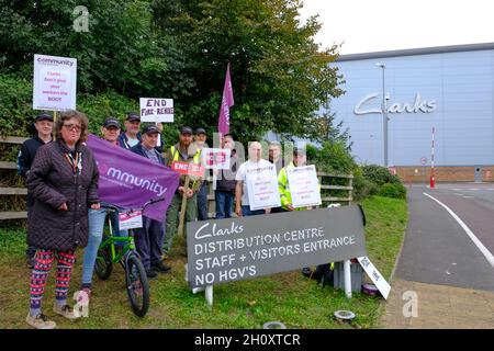 Street, Somerset, Großbritannien. Oktober 2021. Mitarbeiter des Vertriebszentrums der Clarks Shoe Fabrik in Somerset protestieren gegen die Praktiken, die sie als „Feuer und Wiederanstellung“ bezeichnen. Seit dem 4. Oktober streiken sie. Die Arbeitnehmer werden von der Gewerkschaft der Gemeinschaft unterstützt. Clarks gehört der in Hongkong ansässigen Venture Capital-Gesellschaft Lionrock. Kredit: JMF Nachrichten/Alamy Live Nachrichten Stockfoto