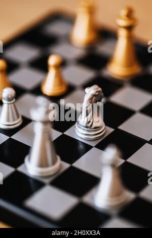 Schachspiel auf einem Brett - silberne und goldene Schachfiguren in einem Duell Stockfoto