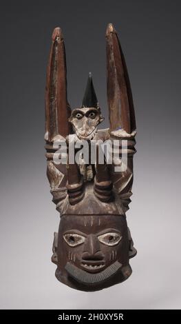 Helm, Ende des 19. Jahrhunderts - Anfang des 19. Jahrhunderts. Afrika, Westafrika, Nigeria, Yorùbá-Völker. Holz und Lack; insgesamt 62.9 cm (24 3/4 in.). Diese Art von Helm, die von der Oro-Vereinigung verwendet wird, wird oft mit dem häufigsten Eungun verwechselt. Während Eungun-Maskeraden zu Ehren der Vorfahren einer Person aufgeführt werden, werden Oro-Maskeraden in Verbindung mit der eigentlichen Beerdigung einer Yoruba-Person durchgeführt. Die Oro-Vereinigung ist sehr geheimnisvoll, und die Sichtbarkeit von Helmen wie diesem ist im Allgemeinen eingeschränkt. Oro ist auch für die Durchführung von Strafstrafen, wie das Sammeln von Geldstrafen, die Wiederbesitznahme von Goo verantwortlich Stockfoto