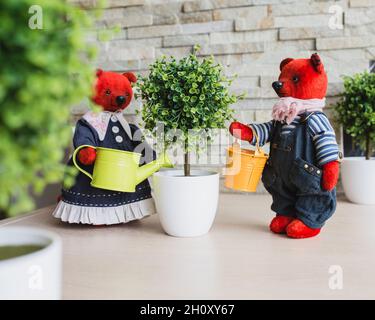 Installation von Spielzeug - Plüsch handgefertigte Bären Bewässerung einer künstlichen Baum im Garten Stockfoto