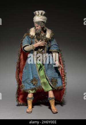 Figur aus einem Crèche: Magus, 1780-1830. Italien, Neapel, Ende des 18.-frühen 19. Jahrhunderts. Lackiertes Holz und Terrakotta mit verschiedenen Textilien; insgesamt 28.7 cm (11 5/16 in.). Die Praxis, Szenen der Geburt Christi für die Heimat zu schaffen, stammt aus dem frühen 17. Jahrhundert in Italien, wo die Menschen begannen, puppenartige Figuren von etwa einem Fuß oder weniger Höhe aufzurichten. Besonders beliebt war der Brauch in Neapel um 1800, wo crèche Szenen (crèche bedeutet Wiege oder Krippe) viele Figuren umfassten, deren Köpfe und Hände aus bemaltem Terrakotta, Stoffkörpern und Kleidung, die an zeitgenössische lokale Kostüme angepasst wurde Stockfoto