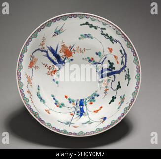 Schüssel: Kakiemon Ware (2 von 2), Ende 1600. Japan, Edo-Zeit (1615-1868). Porzellan; Durchmesser: 35.6 cm (14 in.); Höhe: 13.1 cm (5 3/16 in.). Der chinesische Stil der Dekoration kennzeichnet diese Schale als ein Produkt, das für die Märkte in England, Holland, Frankreich und Deutschland hergestellt wurde. Hier arrangierten kakiemon-Töpfer die chinesischen literati-Motive von Pflaume, Kiefer und Bambus neu. Solche kakiemon-Ware inspirierte die heimische Porzellanproduktion in Europa im 18. Und 19. Jahrhundert. Stockfoto