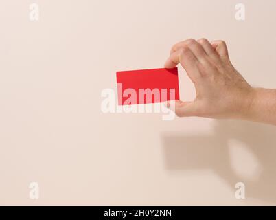 Weibliche Hand hält leeres rotes Papier auf beigem Hintergrund. Kopieren Bild oder Text einfügen, Nahaufnahme Stockfoto