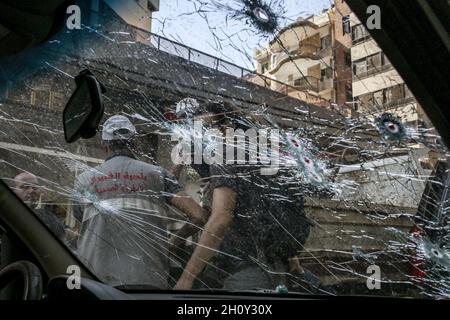 Beirut, Libanon. Oktober 2021. Die Menschen werden von der in der Tayouneh geparkten, von einer Kugel durchlöcherten Frontscheibe aus gesehen, die nach den tödlichen gewalttätigen Zusammenstößen zwischen muslimischen schiitischen Kämpfern der pro-iranischen Hisbollah und Gegnern gestern geparkt war. Bei einem Protest gegen einen Richter, der die massive Explosion im Hafen der Stadt im vergangenen Jahr untersucht, wurden heute in Beirut mindestens sechs Menschen getötet und 32 weitere verletzt. Quelle: Marwan Naamani/dpa/Alamy Live News Stockfoto