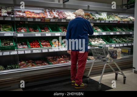 Ein Shopper sieht sich Salatgemüse in einer Waitrose-Filiale im Süden Londons an. Es wird gesagt, dass Käufer eine Reihe von Weihnachtsartikeln wie Geschenke und gefrorene Truthähne früh kaufen, um sicherzustellen, dass ihre festlichen Feierlichkeiten für ein zweites Jahr nicht stark gestört werden. Bilddatum: Freitag, 15. Oktober 2021. Stockfoto