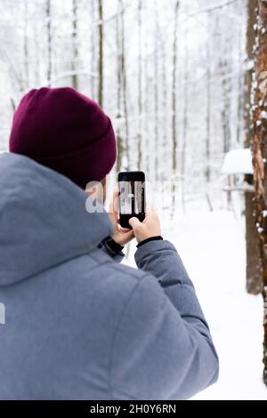 Ein junger Mann fotografiert mit seinem Handy im Wald. Natur Russlands. Stockfoto