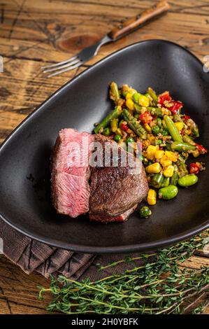 Gegrillte Sirloin-Fleischsteaks, selten gebraten. Holzhintergrund. Draufsicht Stockfoto