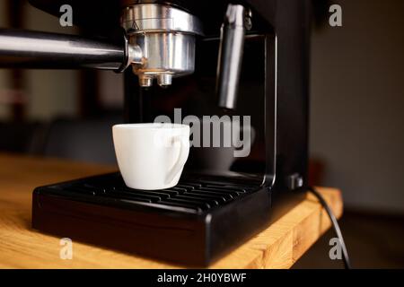 Kaffeemaschine bereit für die Zubereitung Eines Kaffees. Tasse Kaffee wird mit einer Espressomaschine in Einem Café zubereitet. Stockfoto