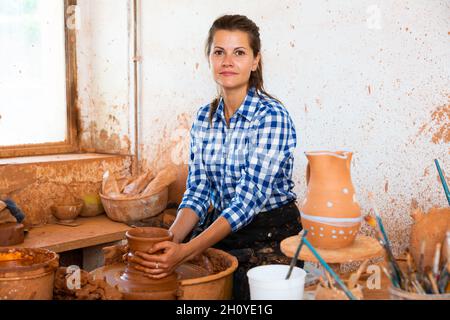 Weibliche Gießkrug auf Töpferscheibe Stockfoto