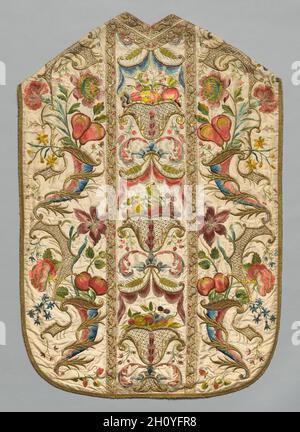 Chasuble, 1700. Italien oder Spanien, 18. Jahrhundert. Stickerei; Seide und Metallfäden; insgesamt: 113.6 x 75.7 cm (44 3/4 x 29 13/16 Zoll). Die exquisite symmetrische Dekoration des Chasuble unterstreicht die zentrale Tafel, in der drei illusionäre Goldbehälter kunstvoll schattierte Früchte in pastellfarbenen Seidentönen halten. Zart geschwungene Motive unterstreichen die Seitenwände ebenso wie fein gestickte Erdbeeren in sogenannten französischen Knoten. Dieses liturgische Chasuble und andere Gewänder, getragen über einer weißen alb mit Spitze, wurden von professionellen Spezialisten bestickt, wie Experten, die farbige Seide schattierten oder g sicherten Stockfoto