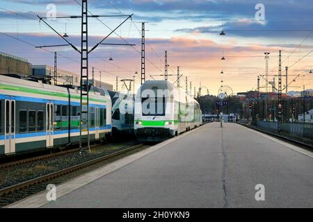 Der moderne elektrische 2-stöckige Personenzug kommt an einem schönen Morgen am Bahnsteig des Helsinkier Bahnhofs an. Stockfoto