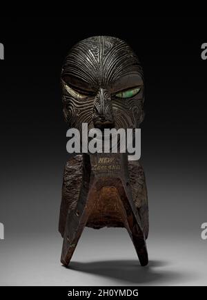 Angeln Kanu prow, 1800er. Polynesien, Neuseeland, Maori, 19. Jahrhundert. Holz mit Haliotis (Perle)-Schaleneinlage; insgesamt 35.3 cm (13 7/8 in.). Komplizierte Oberflächenmuster charakterisieren Maori-Holzschnitzereien. Die Wirbel und Spiralen, die das Gesicht auf diesem Kanu-Prow bedecken, replizieren traditionelle Gesichtstattoo-Muster. Ähnliche Designs wurden für Post- und Giegelfiguren verwendet, die sowohl Wohnungen als auch Verbindungen schmückten. Stockfoto