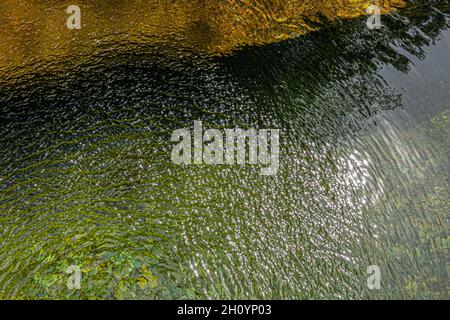 Blick von oben auf das Wasser eines Flusses und einer Felsenbank. Der Wind verleiht dem Ganzen eine hervorragende Textur. Auf dem GR 70, Robert Louis Stevenson Trail, Cevennes, Fra Stockfoto