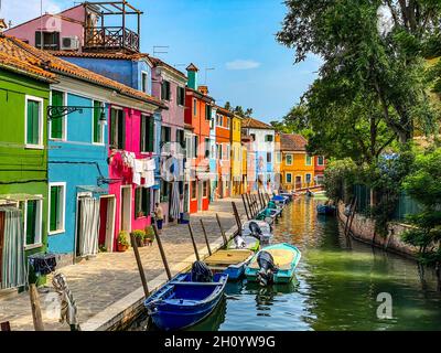 Boote und bunte, traditionell bemalte Häuser in einer Kanalstraße Häuser der Insel Burano, Venedig, Italien Stockfoto