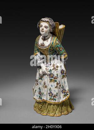 Abbildung, 1745-1750. Strasbourg Factory (Französisch). Fayence; insgesamt: 28.9 x 13.7 x 12.7 cm (11 3/8 x 5 3/8 x 5 Zoll). In der Mitte des 18. Jahrhunderts war die Familie Hannong mehrere Jahrzehnte lang Eigentümer einer der besten und einflussreichsten französischen Fayence-Fabriken in Straßburg. Hier trafen sich deutsche und französische Keramikstile und -Techniken und wurden miteinander verschmolzen. Diese Figuren wurden von einem Paar aus Chantilly-Porzellan kopiert, das wiederum auf einem Meissen-Prototyp basierte. Stockfoto