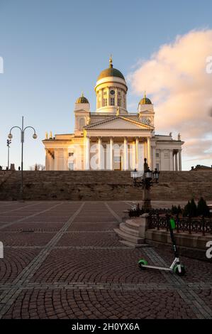 Helsinki / Finnland - 14. MÄRZ 2020: Kathedrale von Helsinki auf einem Hügel bei Sonnenuntergang. Senatsplatz und Alexander-Statue im Vordergrund. Stockfoto