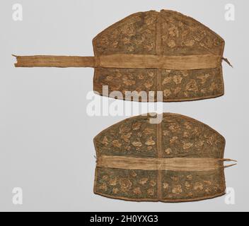 Paar Kopfstücke, 907-1125. China, Liao-Dynastie (907-1125). Stickerei, Seide; insgesamt: 22.3 x 53.8 cm (8 3/4 x 21 3/16 Zoll). Diese Kopfstücke sind bestickt mit Schmetterlingen, Vögeln, Tieren, Blumen, Blättern, Und zarte Weinrollen. Im Allgemeinen ist das Design mit dem Thema des Lotusteich, am besten bekannt aus Liao Grabmalereien verbunden. Paarige Enten oder Gänse, die im Wasser schwimmen und in entgegengesetzte Richtungen schauen, scheinen im Norden Chinas populär geworden zu sein, bevor sie sich weiter nach Süden und nach Zentralasien ausbreiteten. Auf der anderen Seite sind Liegeradtiere, die zurückblicken, ein zentralasiatisches Bild, das Stockfoto