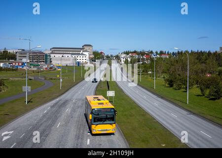 REYKJAVIK, ISLAND - 12. Juni 2021: Blick von einer Njardargata-Überführung auf die Hringbraut Road. Knapper Autoverkehr und gelber Stadtbus. Stockfoto