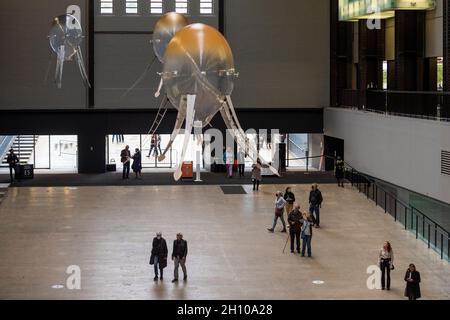 London, Großbritannien. Oktober 2021. Die Besucher sehen schwebende Kunstflugkörper, die Anicka Yis neues Luftwerk „in Love With The World“ bilden, in der Turbine Hall of Tate Modern für die Hyundai-Kommission 2021. Die Installation besteht aus Maschinen, die als Kunstflugkörper bezeichnet werden, basierend auf Lebensformen des Ozeans und Pilzen, die in der Luft schweben, und stellt eine Neueinbildung dar, wie künstliche Intelligenz und neue Maschinen die Welt bewohnen könnten. Die Arbeit kann bis zum 16. Januar 2022 erlebt werden. Kredit: Stephen Chung/Alamy Live Nachrichten Stockfoto