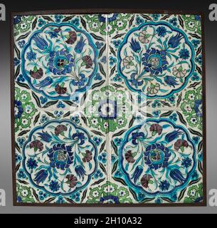 Wandfliesen, 1600er. Türkei (Iznik), Osmanische Zeit. Fritware mit Unterglasur-bemaltem Design; diese vier quadratischen Fliesen sind jeweils mit einem Blumenspray aus Tulpen, Nelken und einer großen hybriden Palmette geschmückt, die in einem zwölflappigen runden Medaillon aufgestellt sind. Es ist von einem achtspitzigen Stern umgeben, der aus Paaren von welligen Linien besteht. Wo die vier Fliesen miteinander verbunden sind, entsteht ein weiteres komplettes Medaillon mit einem Blumenmotiv und einem kobaltblauen Zentrum. Stockfoto