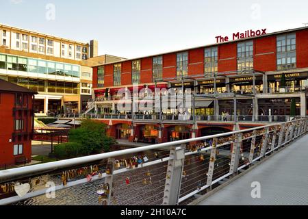 „The Love Lock Bridge“ mit Liebessymbolen über dem Kanal und dem „The Mailbox“-Gebäude im Zentrum von Birmingham, Großbritannien Stockfoto