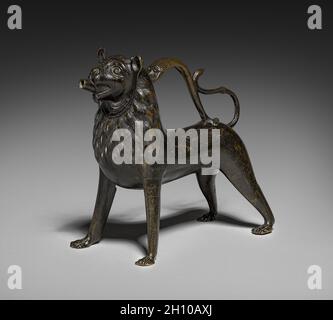 Lion Aquamanile, 1200-1250. Deutschland, Niedersachsen, Hildesheim, Gotik, erste Hälfte 13. Jahrhundert. Bronze: Gegossen, gejagt und gestanzt; insgesamt 26.4 x 29 x 15 cm (10 3/8 x 11 7/16 x 5 7/8 Zoll). Eine Aquamanile ist ein Wasserbehälter, der sowohl an Kirchenaltären als auch an den Esstischen von Gästen der gehobenen Klasse zum Händewaschen verwendet wird. Sie nahmen oft die Form von fantastischen Tieren wie Drachen und Einhörner oder Tiere wie Pferde, Vögel, Hunde und Löwen, wie diese. Stockfoto