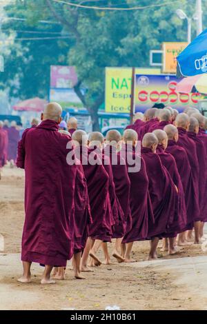 BAGAN, MYANMAR - 8. DEZEMBER 2016: Reihen buddhistischer Mönche sammeln ihre täglichen Almosen. Stockfoto