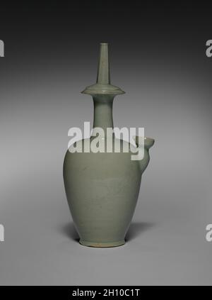 Water Ewer for Rituals with Incised Papagei Design, 1100er. Korea, Goryeo-Zeit (918-1392). Steinzeug mit Seladonglasur, eingeschnitzt und geschnitzt; insgesamt 36.2 x 14 cm (14 1/4 x 5 1/2 in.). Dieses markant geformte Seladongefäß ist eine Kundika. Mit einem Auslauf auf der einen Seite wird diese Art von Gefäß häufig in buddhistischen Reinigungsritualen verwendet. Im Gegensatz zu den meisten existierenden Beispielen, die ein Bild eines Weidenbaums haben, ist auf der Oberfläche dieses Werks ein seltenes fliegendes phoenix-Design eingeschnitten. Stockfoto