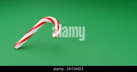 Frohe Weihnachten Stöcke, Lutscher Minze Süßigkeiten mit roten Streifen auf grünem Hintergrund. Konzept für die Feier zum neuen Jahr. Traditionelles süßes Dessert. 3d-Rendering Stockfoto
