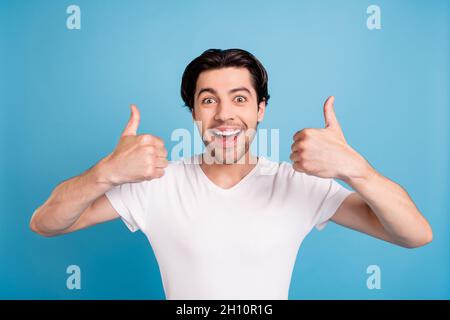 Foto von froh erstaunt verrückt positiven Kerl heben Daumen nach oben offenen Mund tragen weißen T-Shirt isoliert blauen Hintergrund Stockfoto