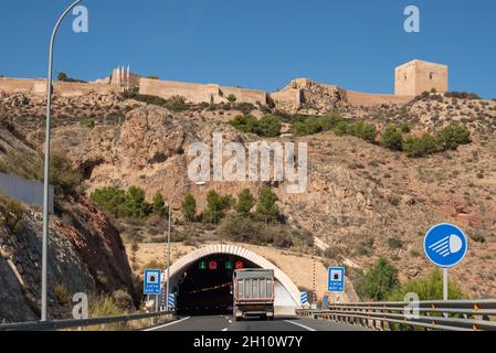 Burg von Lorca, oberhalb des Straßentunnels A-7 in Lorca, Region Murcia, Spanien. Historisches Castillo de Lorca Wahrzeichen hoch über der Autobahnausfahrt Stockfoto