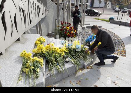 Kiew, Ukraine. Oktober 2021. KIEW, UKRAINE - 14. OKTOBER 2021 - Ein Mann legt Blumen an die Gedenkstätte für die Soldaten, die im Krieg der Russischen Föderation gegen die Ukraine während der Gedenkfeier anlässlich des Tages der Verteidiger und Verteidiger der Ukraine starben, Kiew, Hauptstadt der Ukraine Kredit: Ukrinform/Alamy Live News Stockfoto