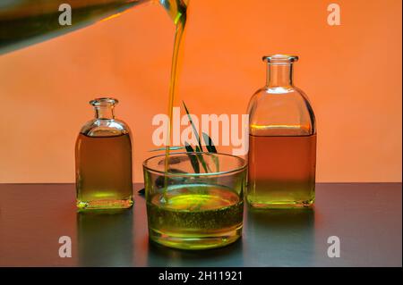 Flaschen von nativem Olivenöl, mit farbigem Hintergrund. Stockfoto