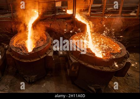 Ein Strahl aus geschmolzenem Stahl wird in Schöpfkellen gegossen. Metallurgische Industrie Stockfoto