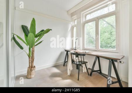 Minimalistischer Arbeitsraum mit Tisch, Stuhl und Zimmerpflanzen Stockfoto