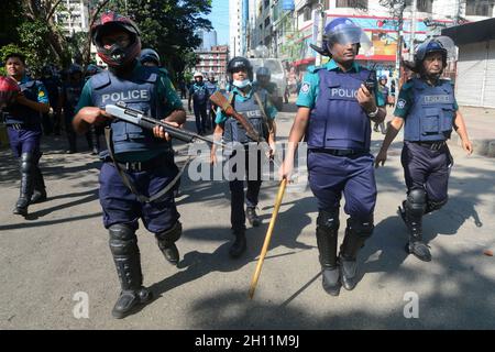 Dhaka, Bangladesch. Oktober 2021. Polizeipersonal bereitet sich darauf vor, während einer Demonstration nach den Freitagsgebeten in der Nähe einer Moschee in Dhaka, Bangladesch, am 15. Oktober 2021 Tränengas auf Demonstranten abzufeuern. Als die Proteste am 13. Oktober begannen, nachdem während der Feierlichkeiten zum Hindu-Fest von Durga Puja Aufnahmen von einem Heiligen Koran auf dem Knie einer Figur eines Hindu-gottes auftauchten. Kredit: Mamunur Rashid/Alamy Live Nachrichten Stockfoto