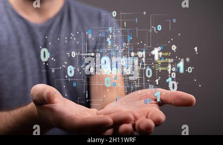Darstellung von Binärcodes in einer menschlichen Hand, die einen transparenten Bildschirm berührt Stockfoto