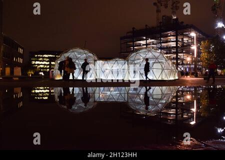 London, Großbritannien. Oktober 2021. Pollution Pods von Michael Pinsky spiegeln sich in den Brunnen vor Central Saint Martins am Granary Square, King's Cross. Die Installation besteht aus fünf geodätischen Kuppeln, die jeweils eine andere Umgebung und Luftqualität enthalten, und ermöglicht es den Besuchern, die saubere Luft von Tautra in Norwegen und die Verschmutzung von Neu Delhi, Peking, Sao Paulo und London zu erleben. Kredit: Vuk Valcic / Alamy Live Nachrichten Stockfoto