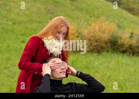 Wer? Mädchen schließt die Augen ihres Freundes, die von hinten aufsteigen Stockfoto