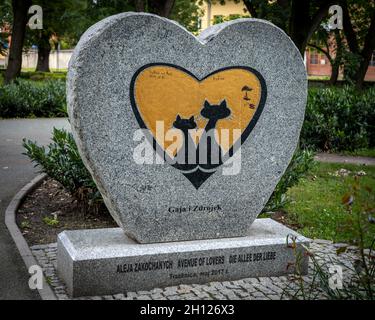 Trzebnica, Polen - 29. August 2021: Ein herzförmiges Steindenkmal eines Katzenpaares "Gaja und Zdrojek", das sich im öffentlichen Park befindet. Stockfoto