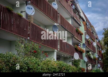 Trzebnica, Polen - 29. August 2021: Ein Wohnblock mit Balkon und vielen Satelliten-TV-Antennen. Stockfoto