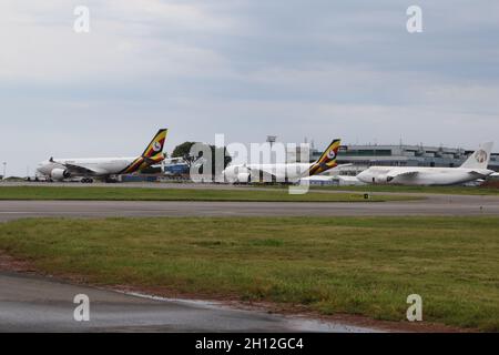 (211015) -- ENTEBBE (UGANDA), 15. Oktober 2021 (Xinhua) -- Flugzeuge werden am 6. Oktober 2021 auf dem neu sanierten Vorfeld am Entebbe International Airport in Entebbe, Uganda, gesehen. Auf dem Asphalt des ugandischen Entebbe International Airport am Ufer des Viktoriasees legen chinesische Techniker und ihre ugandischen Kollegen beim ein- und Ausfliegen der Flugzeuge den letzten Schliff auf die Schürzen. Der 70 Jahre alte Flughafen, der 1951 von den britischen Kolonialmeistern eröffnet, Anfang der 1970er Jahre renoviert und jetzt von China finanziert wird, ist Ugandas Haupttor zur Welt. (Xinhua/Zhang Gaiping Stockfoto