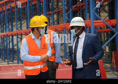 (211015) -- ENTEBBE (UGANDA), 15. Oktober 2021 (Xinhua) -- Li Qinpu (L, Front), Projektleiter der China Communications Construction Company (CCCC), und Ayub Sooma (R, Front), Direktor für Flughäfen und Flugsicherheit bei der Uganda Civil Aviation Authority, sprechen am 6. Oktober 2021 im neu errichteten Frachtzentrum des Entebbe International Airport in Entebbe, Uganda. Auf dem Asphalt des ugandischen Entebbe International Airport am Ufer des Viktoriasees legen chinesische Techniker und ihre ugandischen Kollegen beim ein- und Ausfliegen der Flugzeuge den letzten Schliff auf die Schürzen. Der 70 Jahre alte Flughafen wurde eröffnet Stockfoto